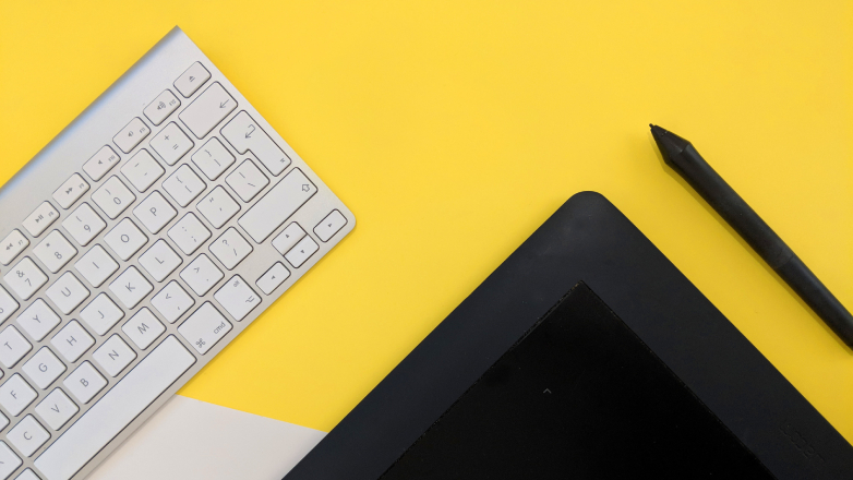 Keyboard and tablet on yellow background