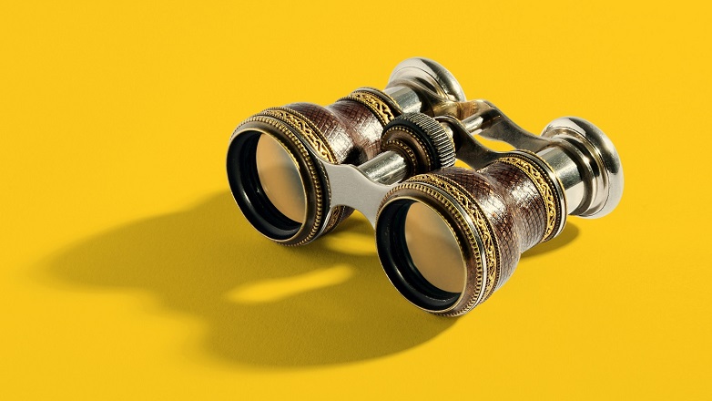 old style binoculars on yellow background